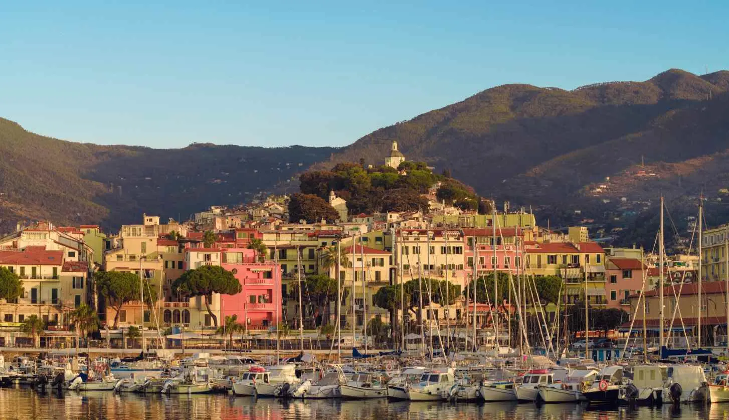 a harbor filled with lots of boats next to a mountain